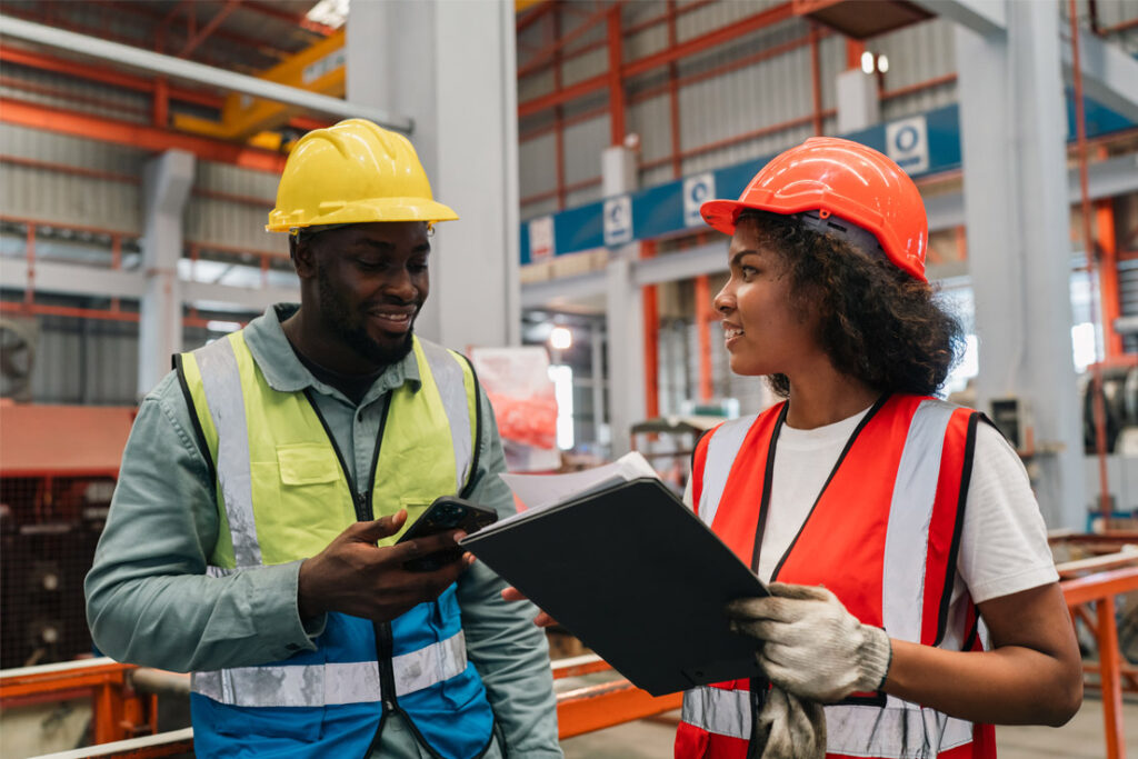 Lean management team reviewing workplace organisation and process improvement procedures in a manufacturing facility