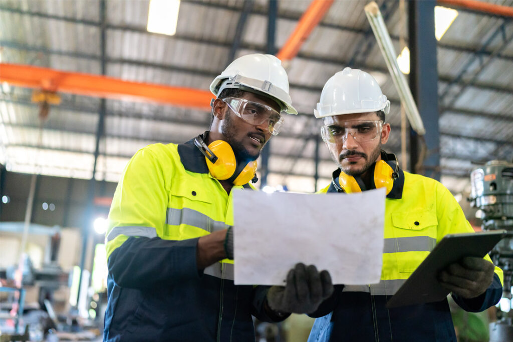 Internal auditor reviewing integrated management system compliance procedures in an industrial environment