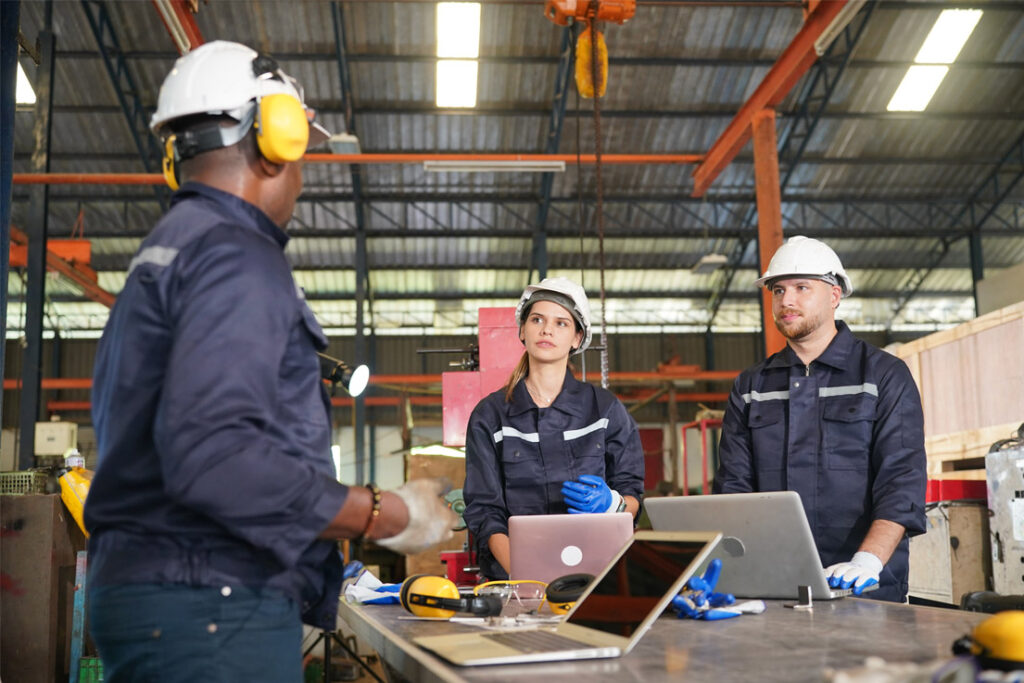 Internal quality auditor reviewing manufacturing procedures and compliance records in a production environment