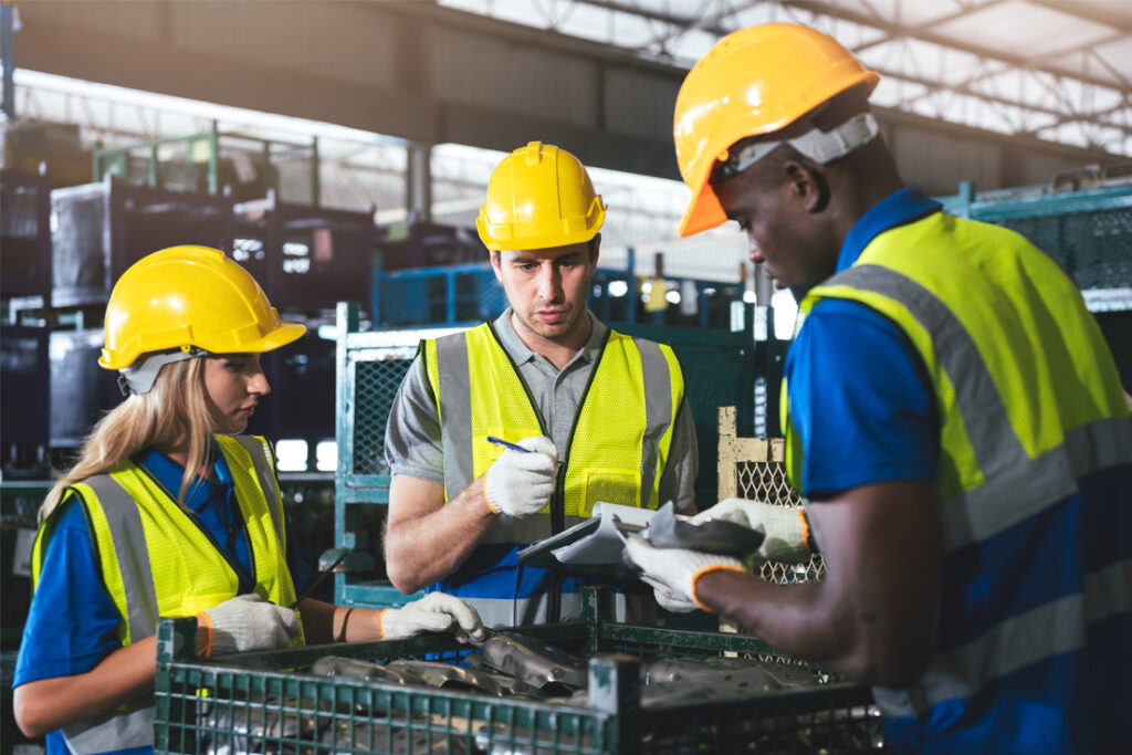 Quality management professionals reviewing implementation procedures in a manufacturing facility